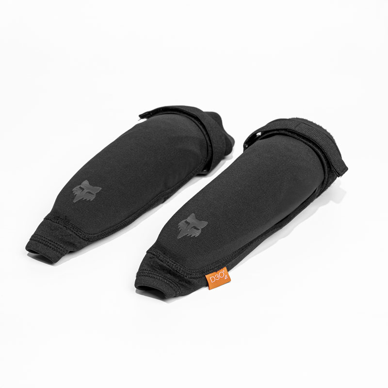 Ein Paar schwarze Ellenbogenschoner mit einem Fuchslogo und einem orangefarbenen Etikett auf weißem Hintergrund.