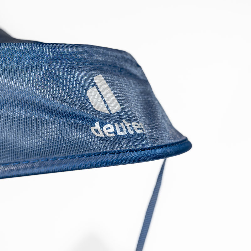 Nahaufnahme des blauen Kindertrage-Stoffes von Deuter mit Logo und sichtbarem Riemen.