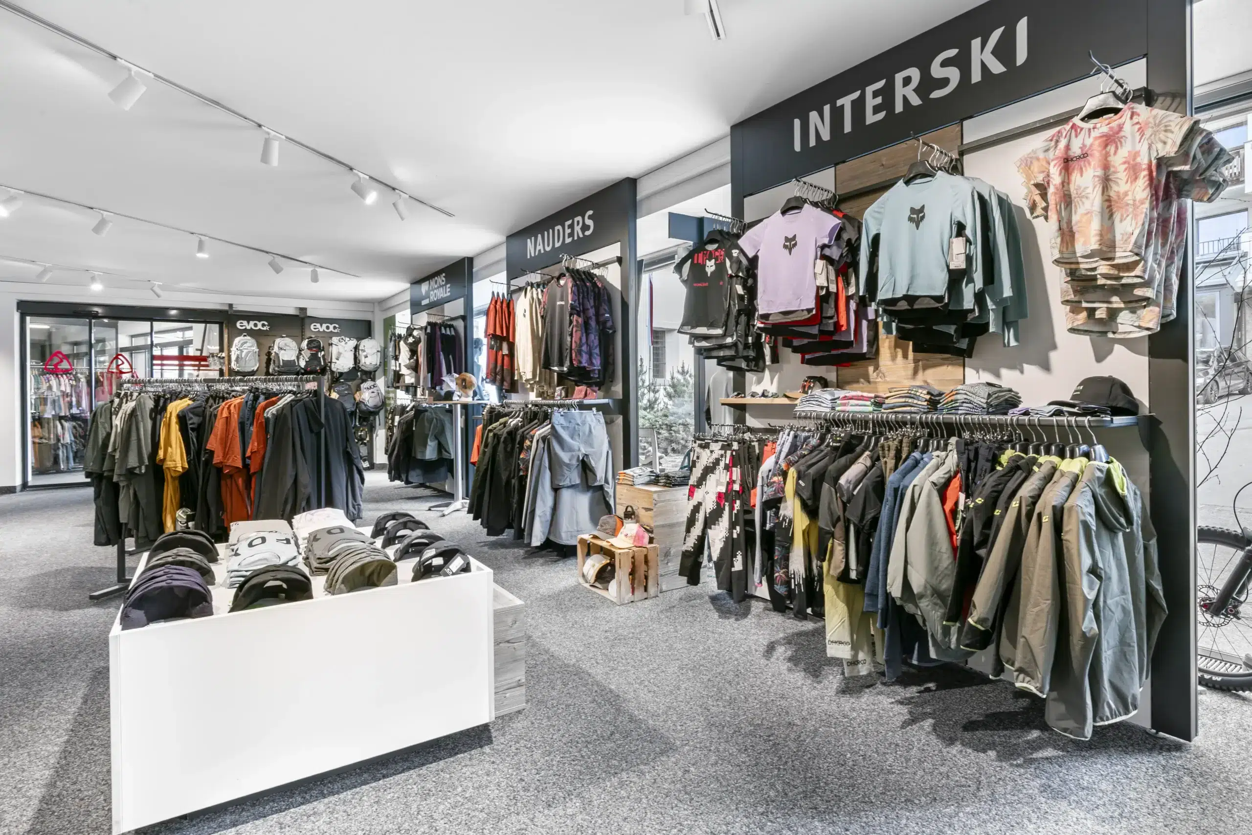 Inneneinrichtung eines Bekleidungsgeschäfts mit ausgestellten Jacken, Hemden und Accessoires.