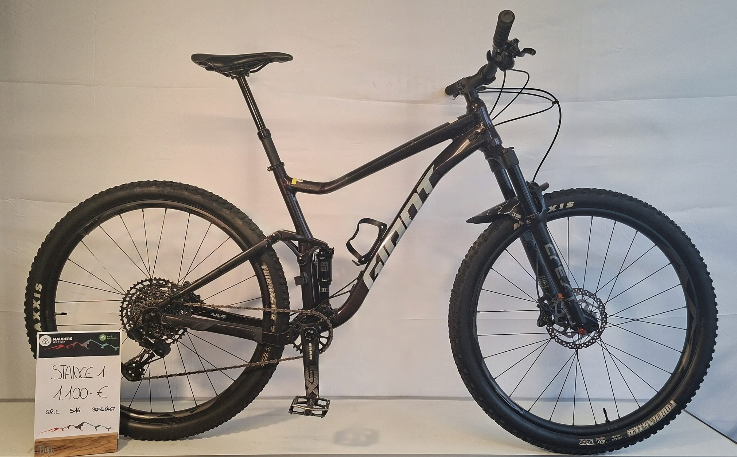 Ein schwarzes Giant Stance 1 Mountainbike mit einem Schild, das den Preis von 1.100 Euro angibt.
