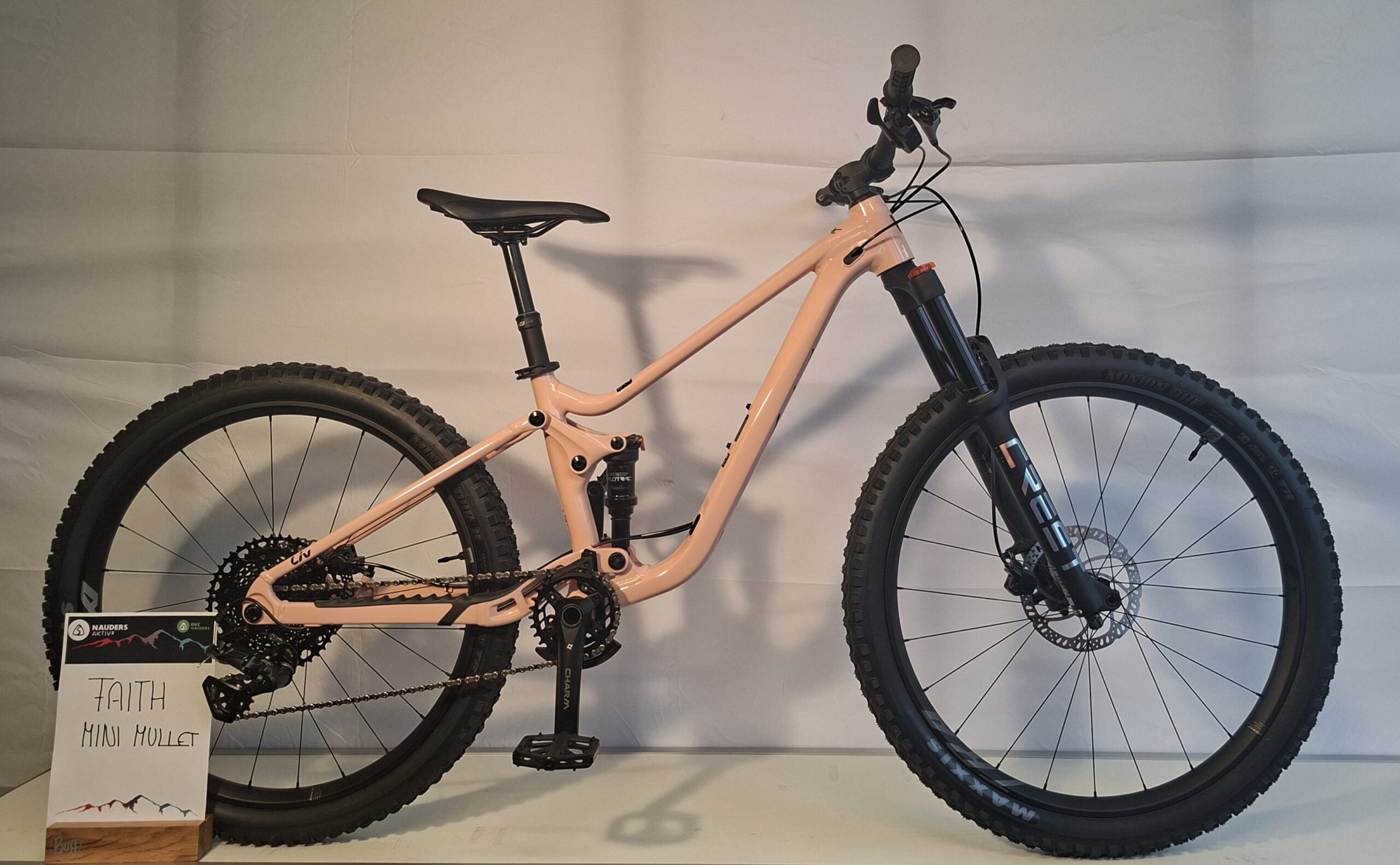 Ein pfirsichfarbenes Giant Faith Mini Mullet (neu) Mountainbike ist zu sehen.